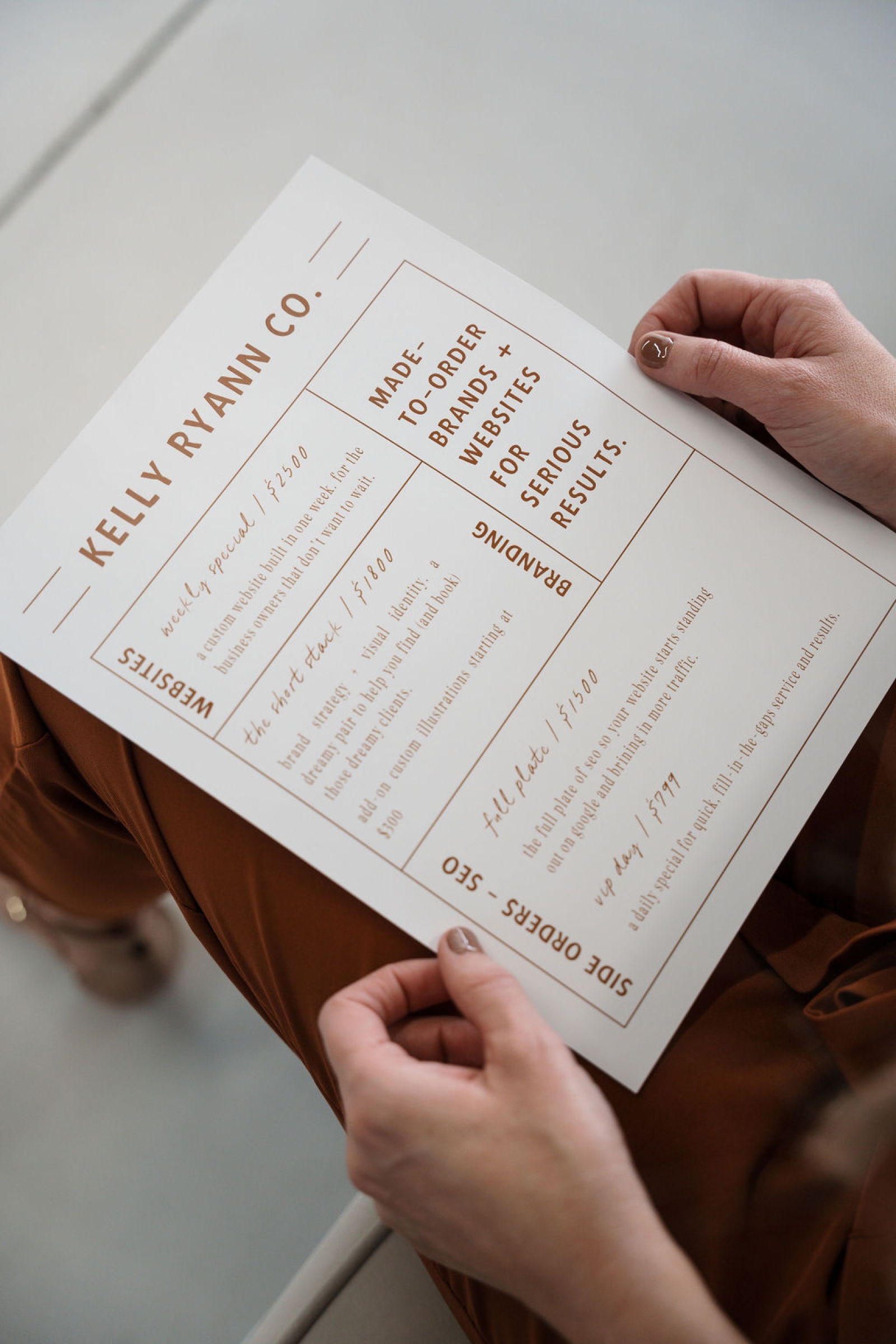 A white paper with brown print outlining Kelly Ryann Co.'s website building packages